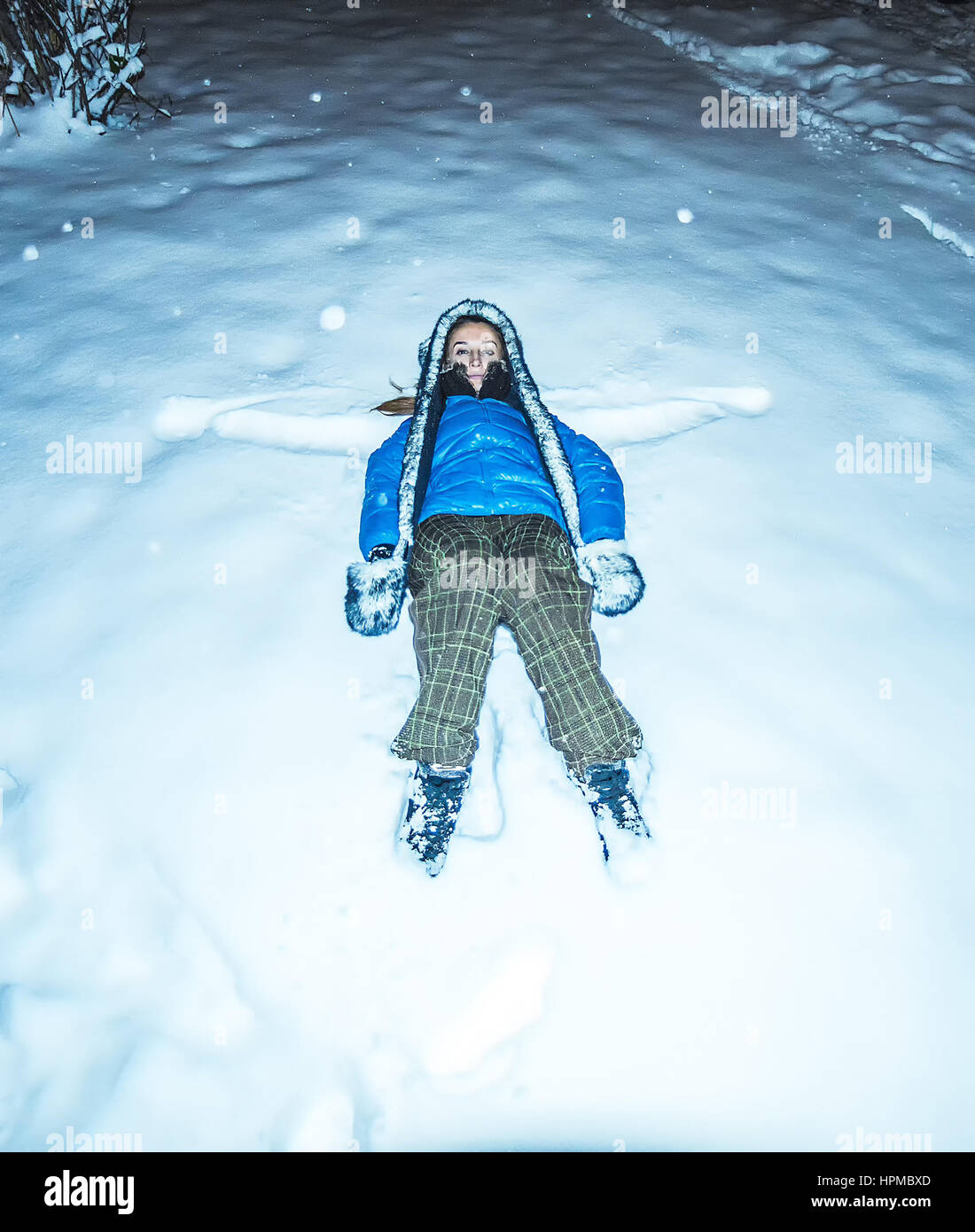 blaue Mädchen Jacke Furhat liegenden Schnee in der Nacht Stockfoto
