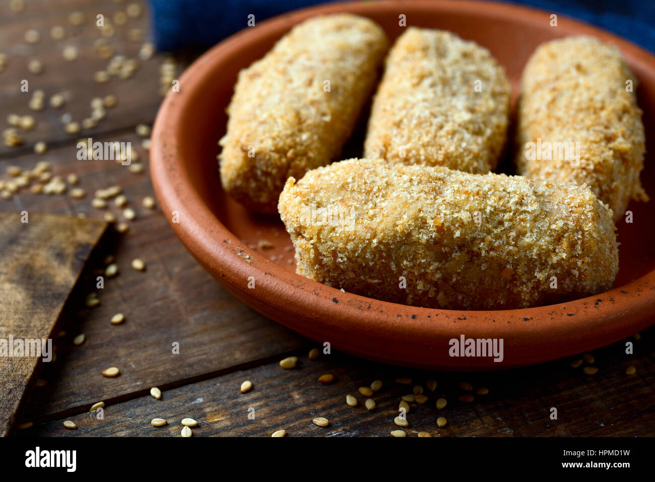 Nahaufnahme eines Steingut Platte mit einigen ungekochten hausgemachte Croquetas, spanische Kroketten auf einem rustikalen Holztisch Stockfoto