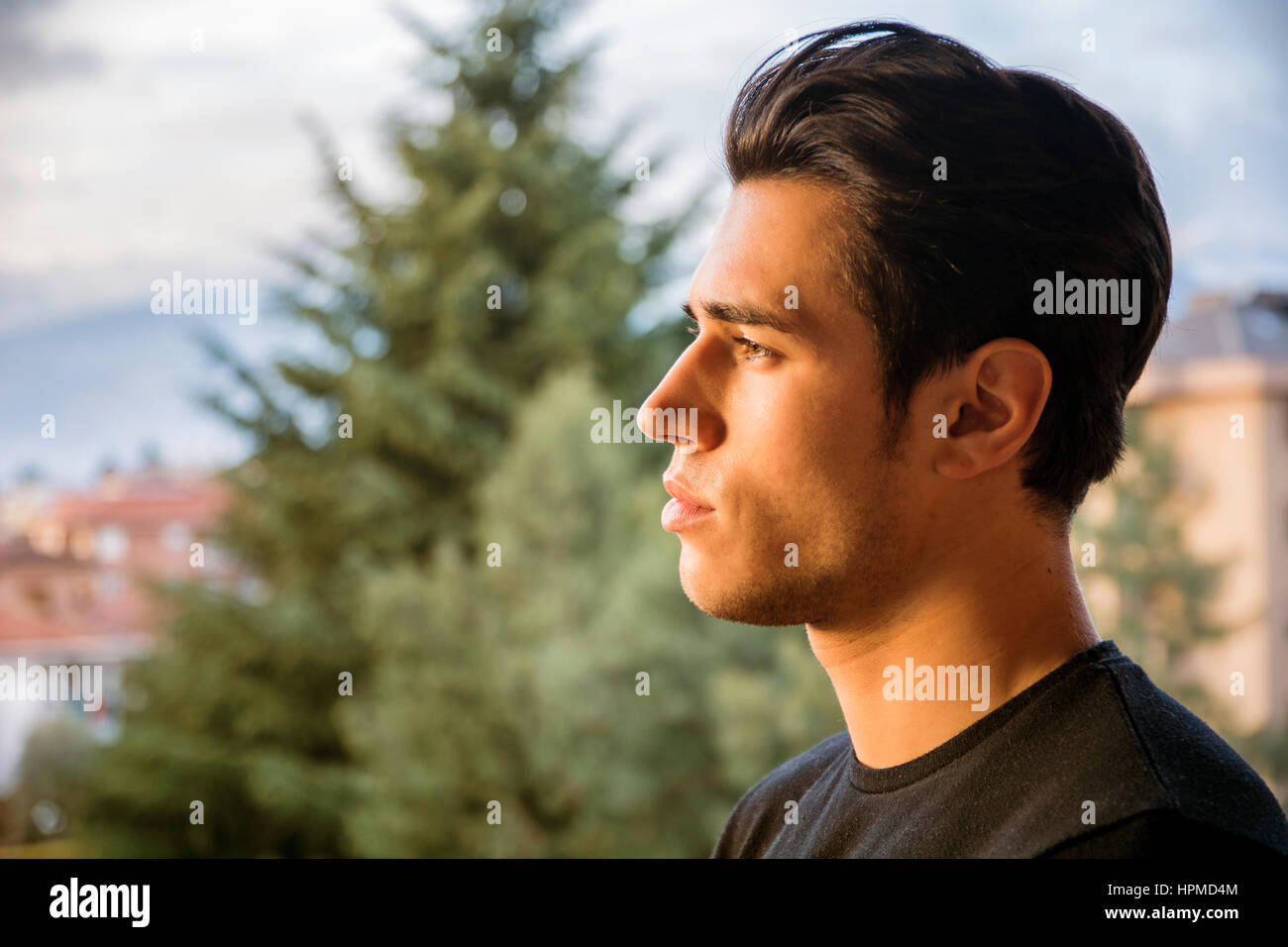 Profil-Kopfschuss von hübscher attraktiver junger Mann im Freien, auf der Suche auf einer Seite Stockfoto