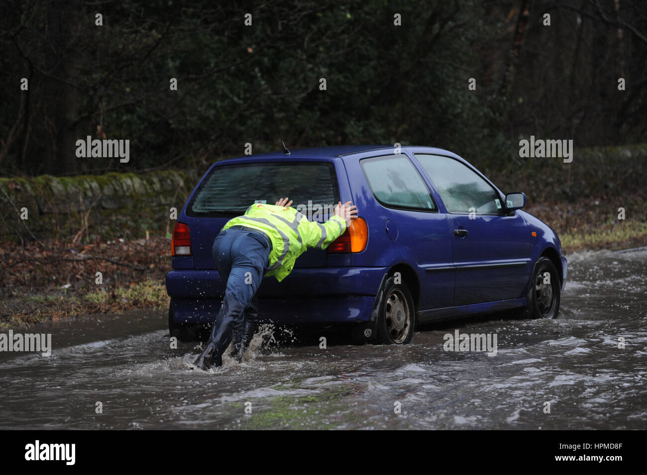 Ein Mann schiebt einen gestrandeten Fahrzeug: Überschwemmungen auf der A616 Stocksbridge Umgehungsstraße in der Nähe von Sheffield, South Yorkshire, Vereinigtes Königreich, während der Sturm Doris. Stockfoto