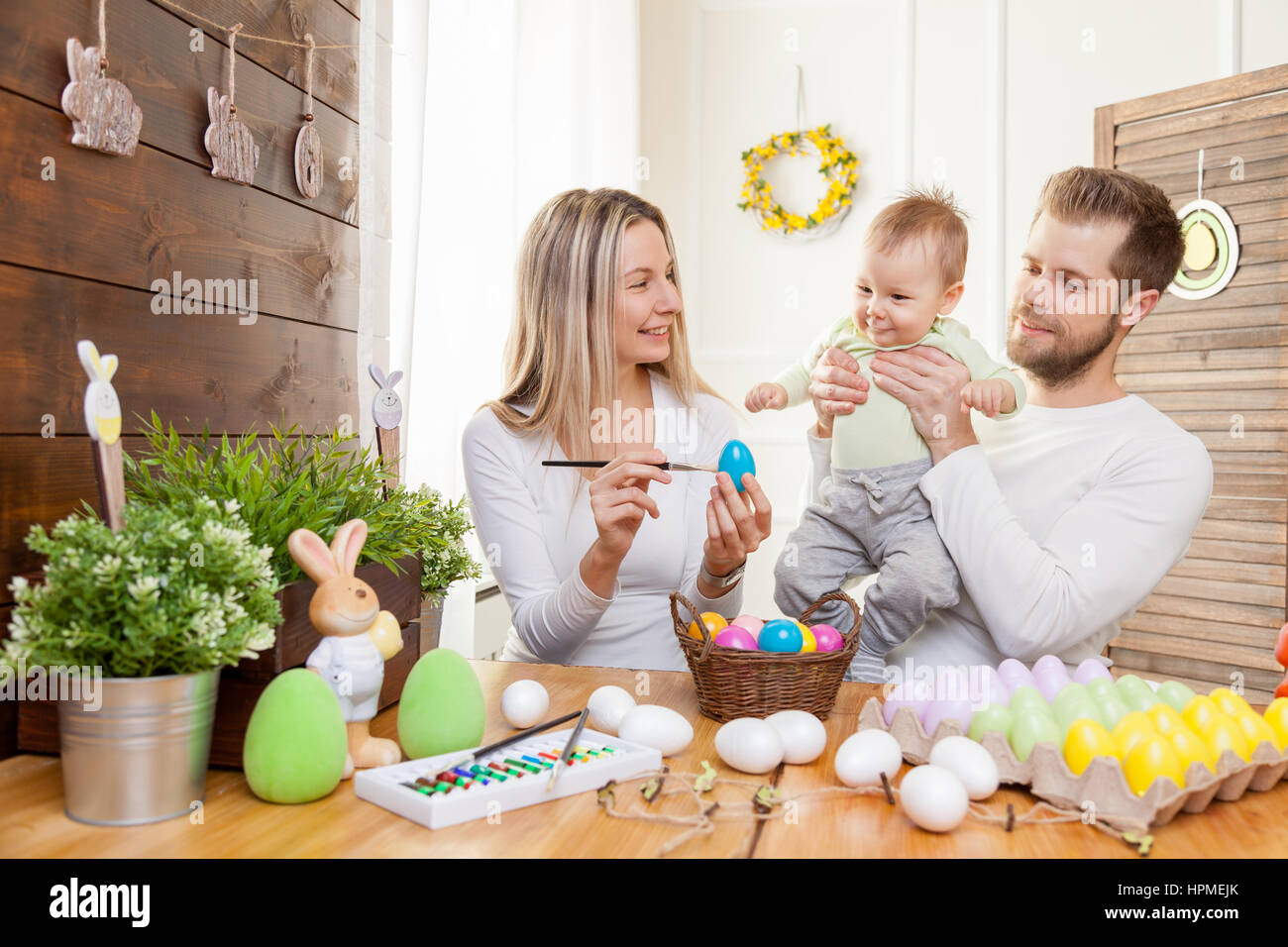 Ostern-Konzept. Glückliche und liebevolle Mutter und Vater Vorbereitung Heimtextilien mit ihrem Kind für die Osterferien Stockfoto