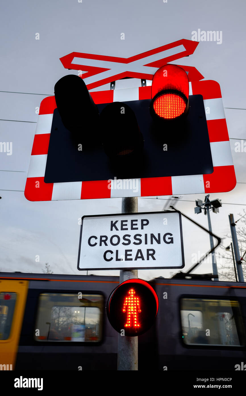 Fußgänger und Straße überqueren die Tyne and Wear Metro in Kingston Park, Newcastle. Stockfoto