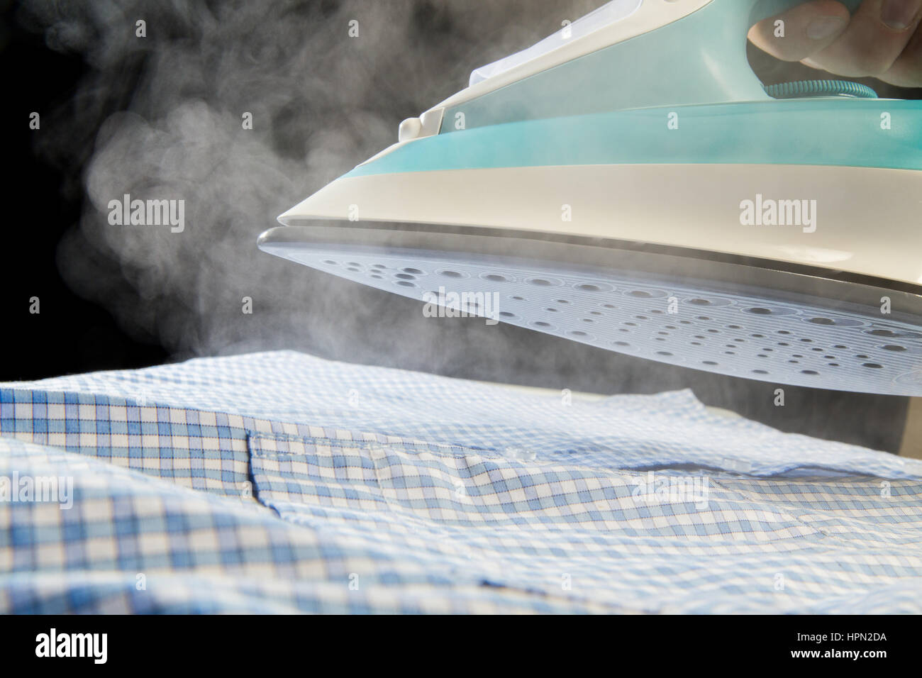 Bügeleisen Dampf über blaues Hemd Abblasen Stockfoto