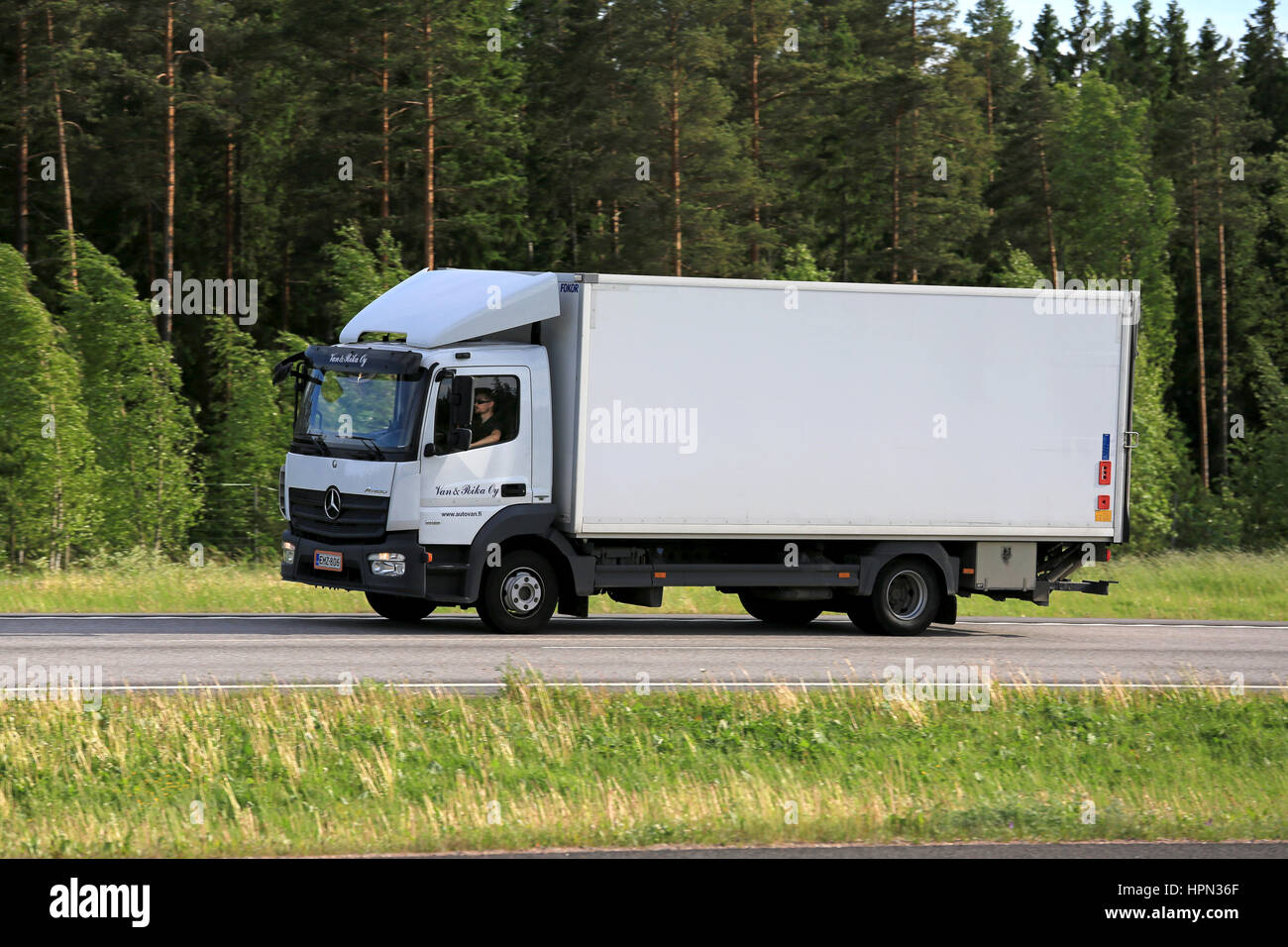 PAIMIO, Finnland - 3. Juni 2016: Weiße Mercedes-Benz Atego Lieferwagen transportiert Güter entlang der Autobahn an einem Sommerabend. Stockfoto