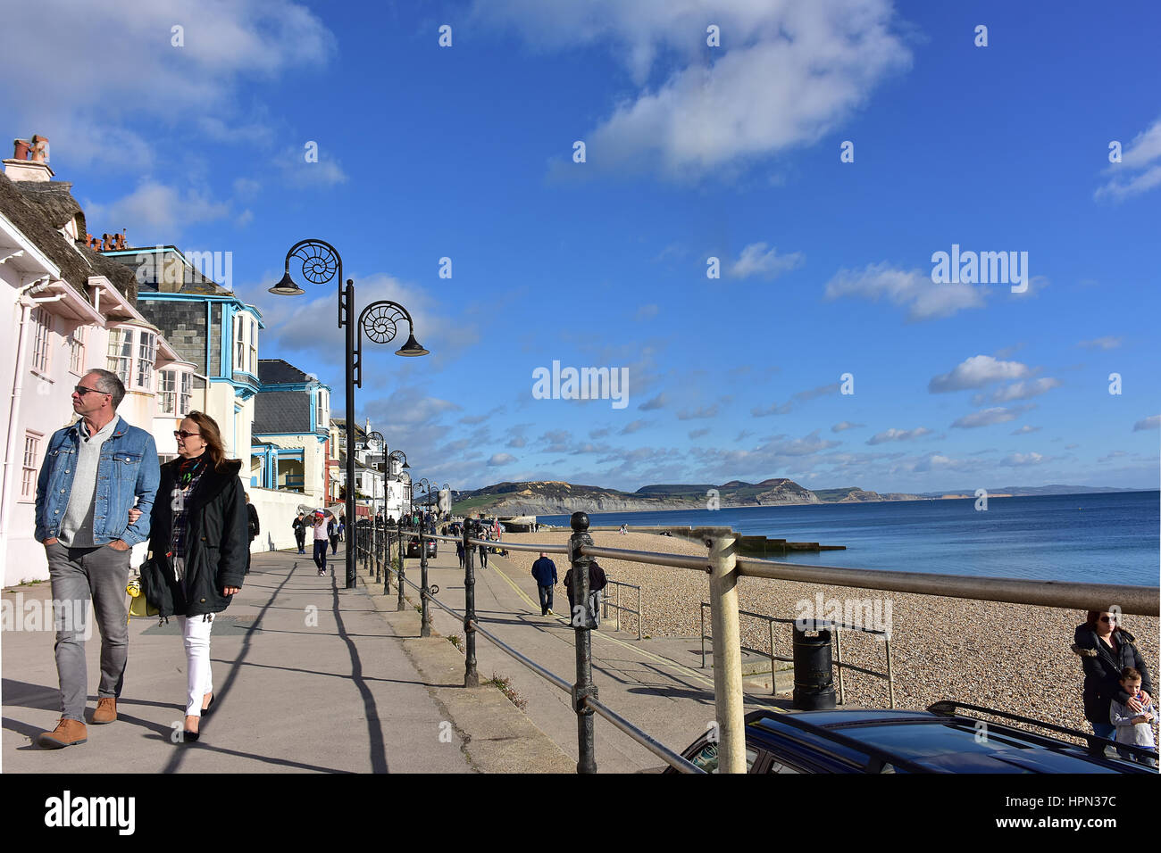 Reifes Paar zu Fuß an der Strandpromenade in Lyme Regis, Dorset, Großbritannien. Stockfoto
