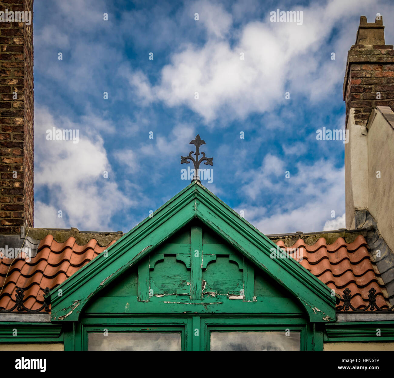 Grün lackierter Holzdormer in rotem Ziegeldach mit dekorativen Metallarbeiten oben, Thirsk, North Yorkshire, Großbritannien. Stockfoto