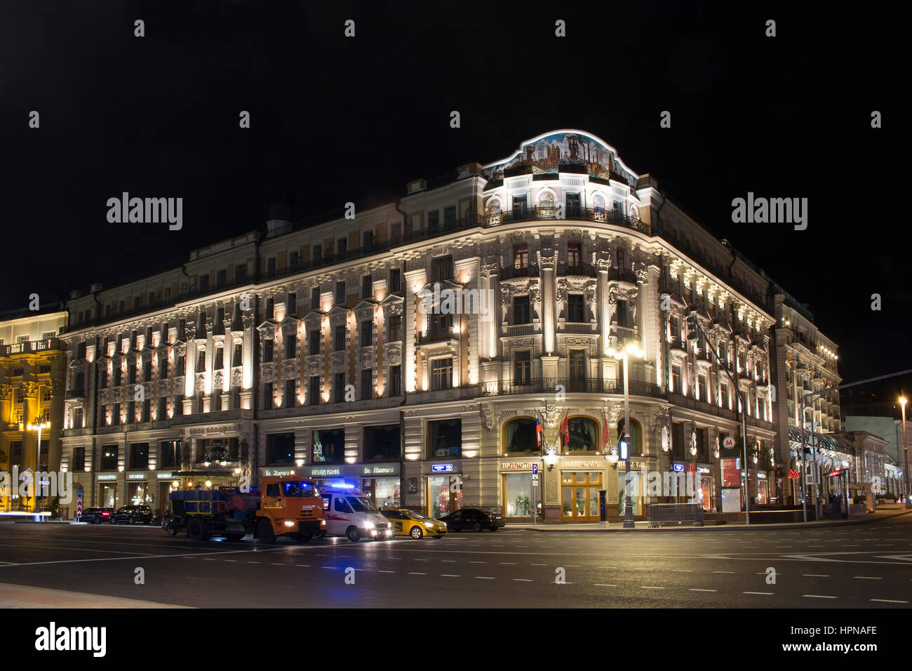 Blick auf ein Luxury Collection Hotel - National in der Nacht in Moskau im Jahre 1903 gebaut. Krankenwagen, Taxi und LKW warten an der Ampel vor ihm. Stockfoto