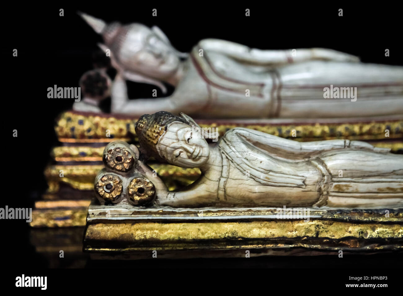 Winzige schlafende Buddhastatuen hergestellt aus weißem Marmor im alten Thai-Stil. Stockfoto