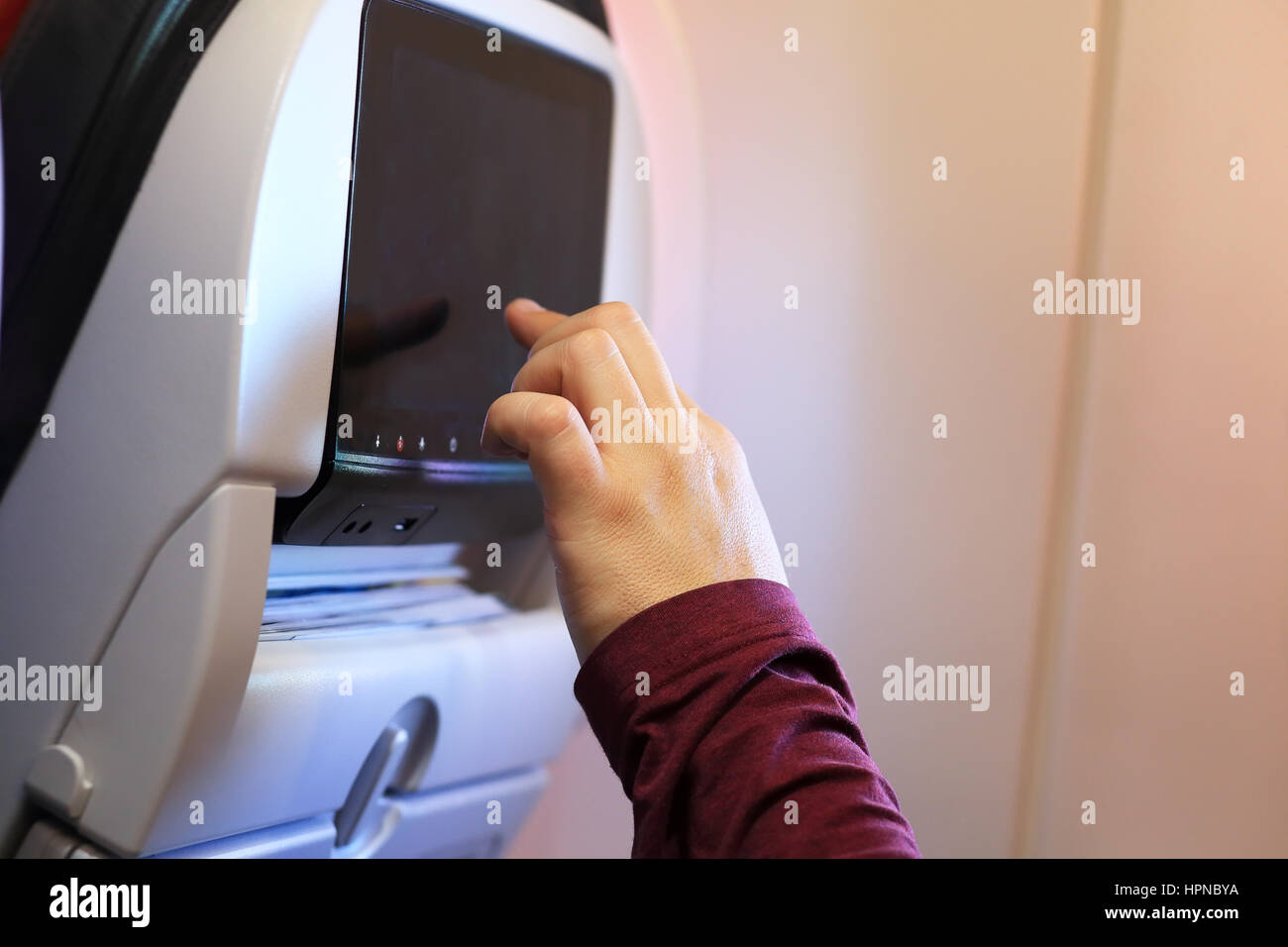 Hand zu berühren schwarzen Bildschirm im Flugzeug Stuhl Stockfoto