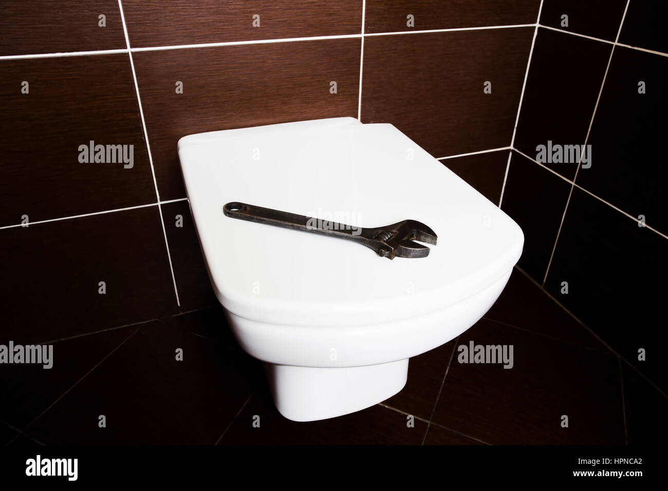 Schraubenschlüssel auf weiße Toilette. WC nach Reparaturen. Stockfoto