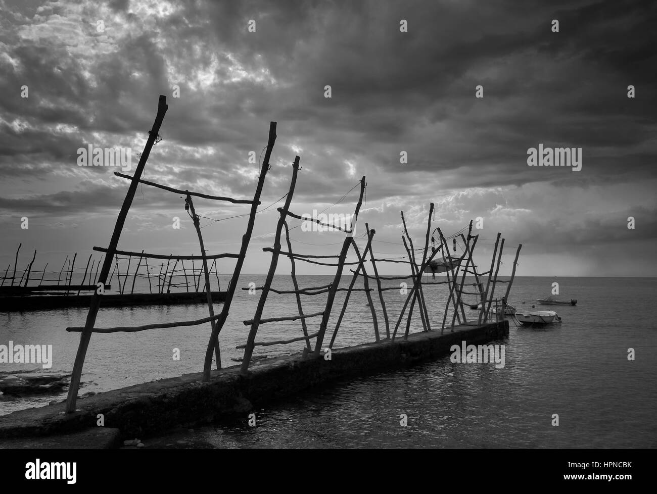 Boote von Savudrija Boote von traditionellen hölzernen Kranen mit Leuchtturm im Hintergrund hängen hängen.  Hängende Boote von Istrien, Kroatien. Angelboot/Fischerboot Stockfoto