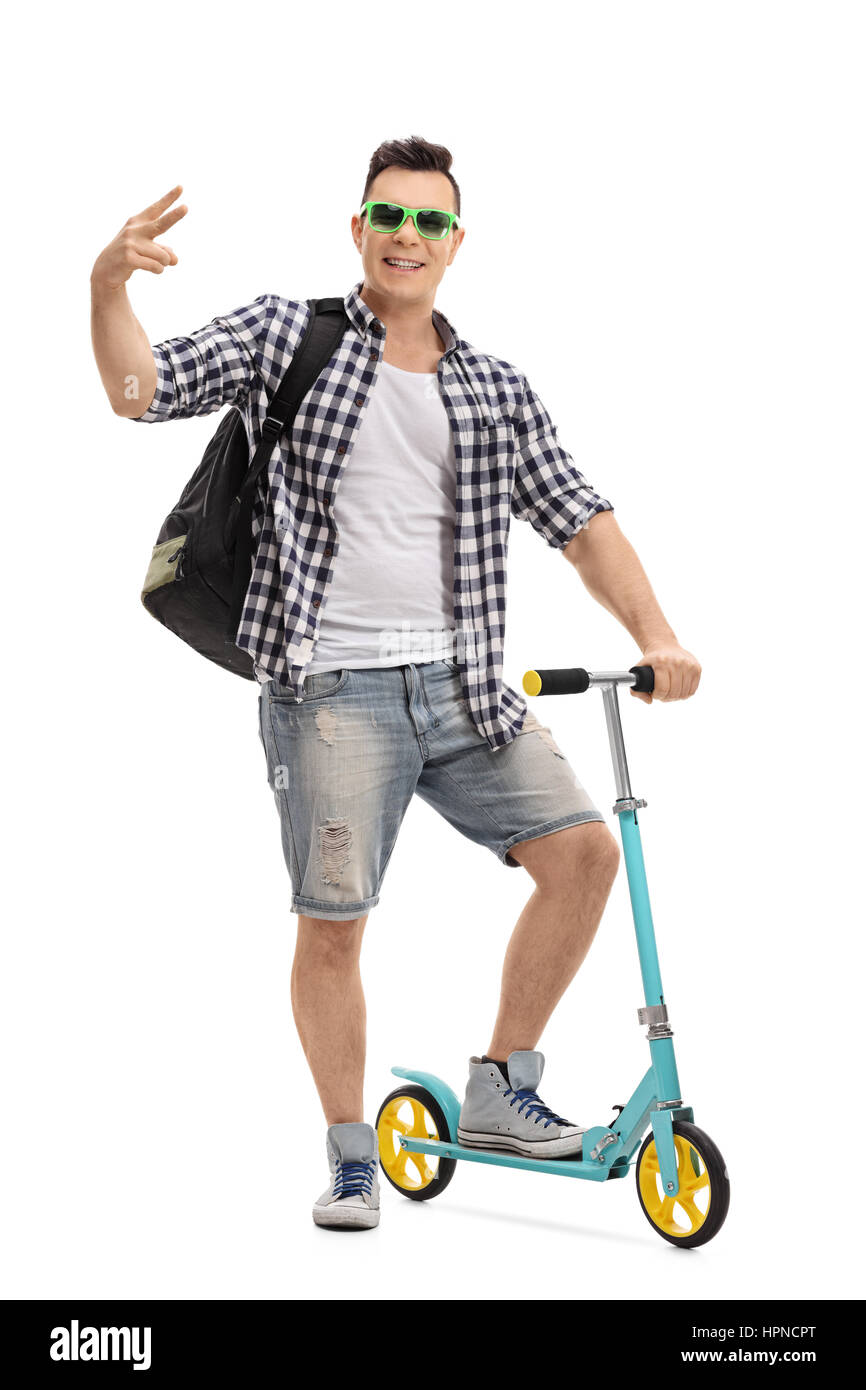 Voller Länge Porträt eines fröhlichen cool mit einem Scooter gestikulieren mit seiner Hand isoliert auf weißem Hintergrund Stockfoto