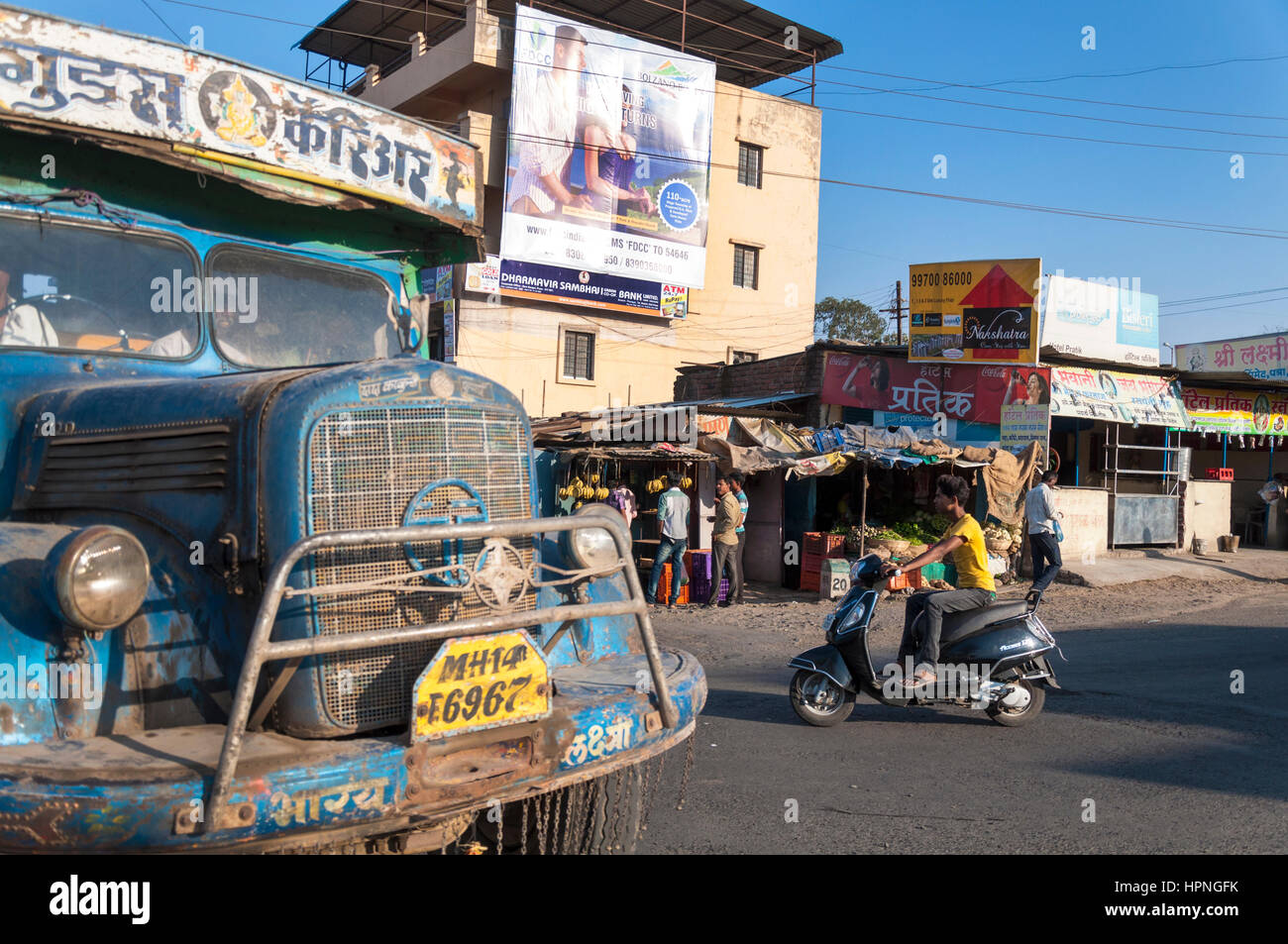 Straße in Pune mit Verkehr LKW Moped und Werbetafeln Stockfoto