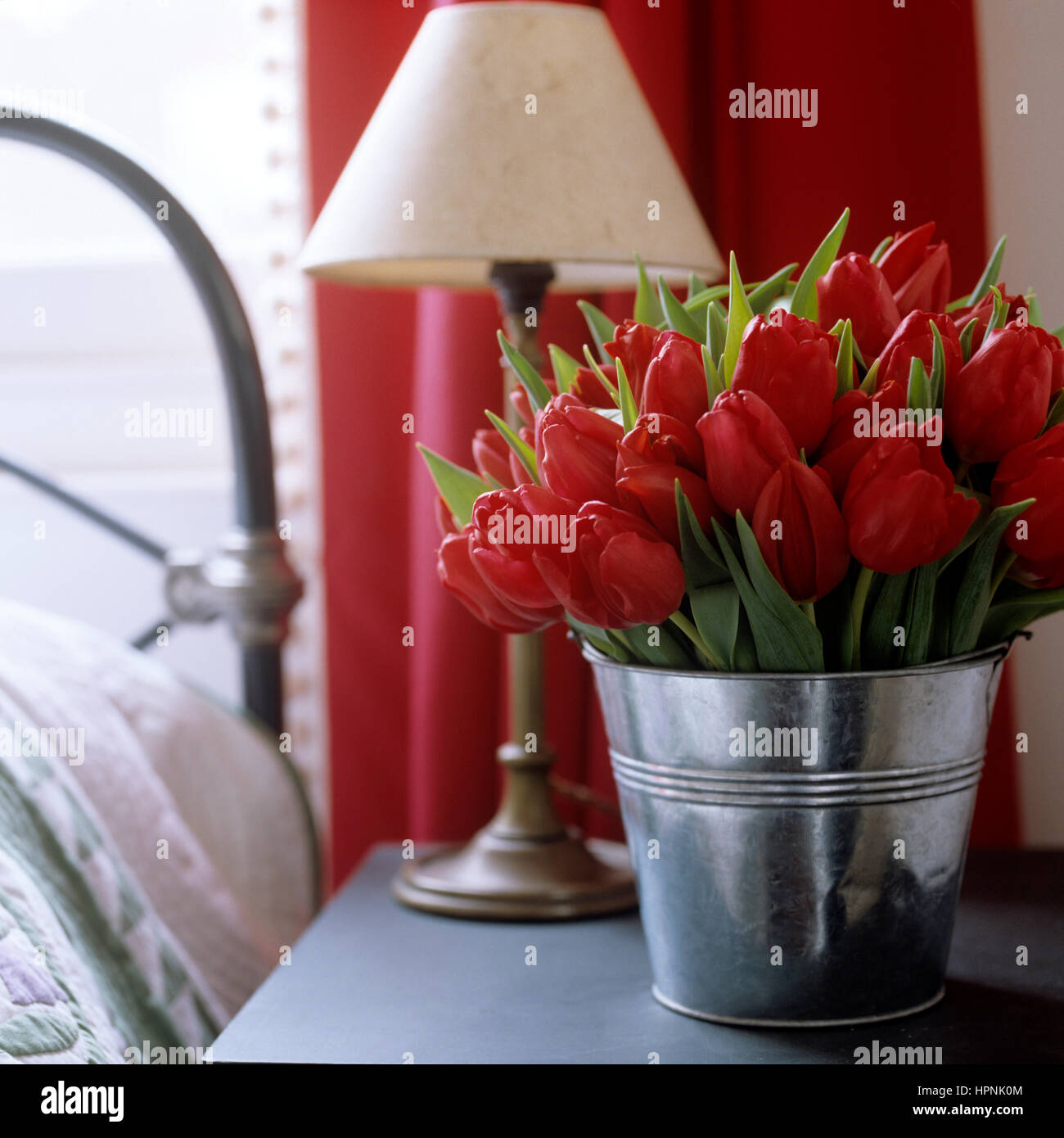 Einen Eimer mit Tulpen auf einem Nachttisch. Stockfoto