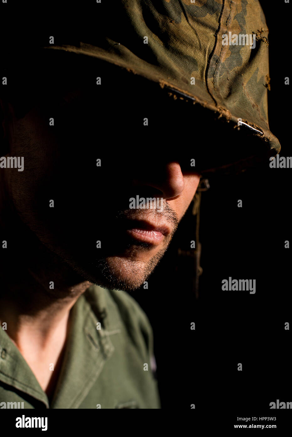 Amerikanischer Soldat (Vietnam-Krieg) mit Gesicht im tiefen Schatten mit PTBS leiden. Stockfoto