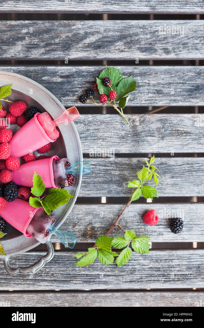 Zinn Teller mit hausgemachten Limonade Eis am Stiehl mit Himbeeren und Brombeeren Stockfoto