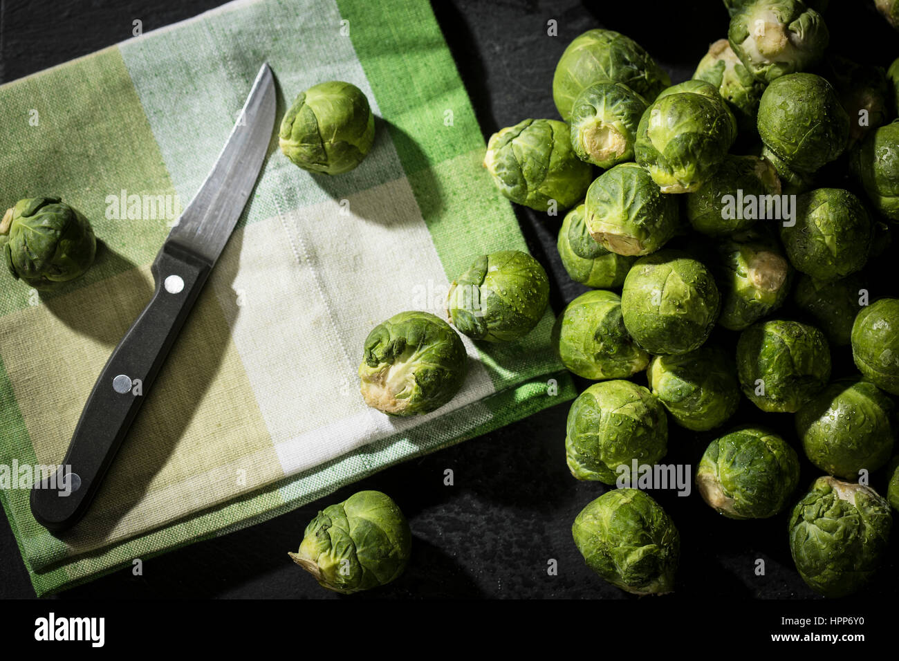 Rosenkohl, Tuch und Küche Messer auf Schiefer Stockfoto