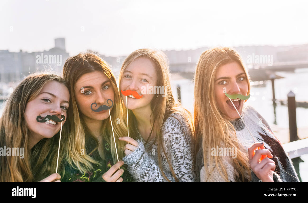 Porträt von vier Freunden mit Spielzeug Schnurrbärte Stockfoto