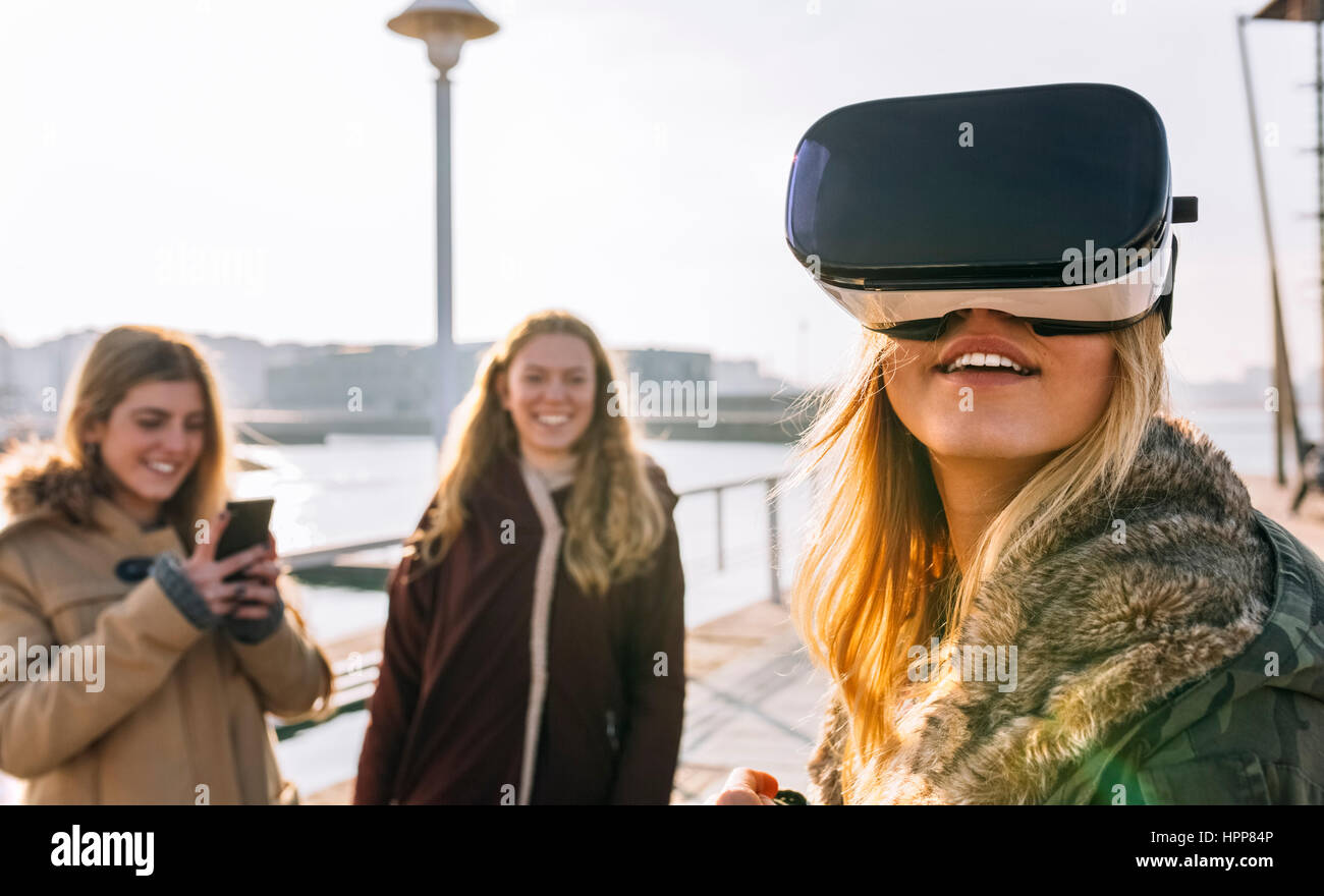 Teenager-Mädchen mit VR-Brille während ihr Freund beobachtete Stockfoto