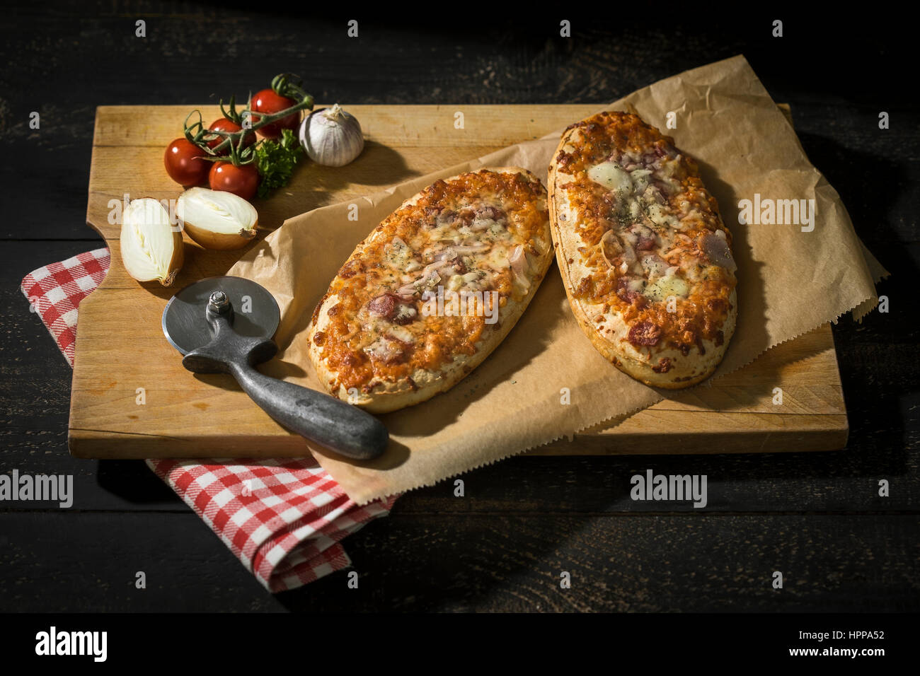 Zwei Pizza-Brot mit Tomaten, Zwiebeln, Salami und Käse Stockfoto