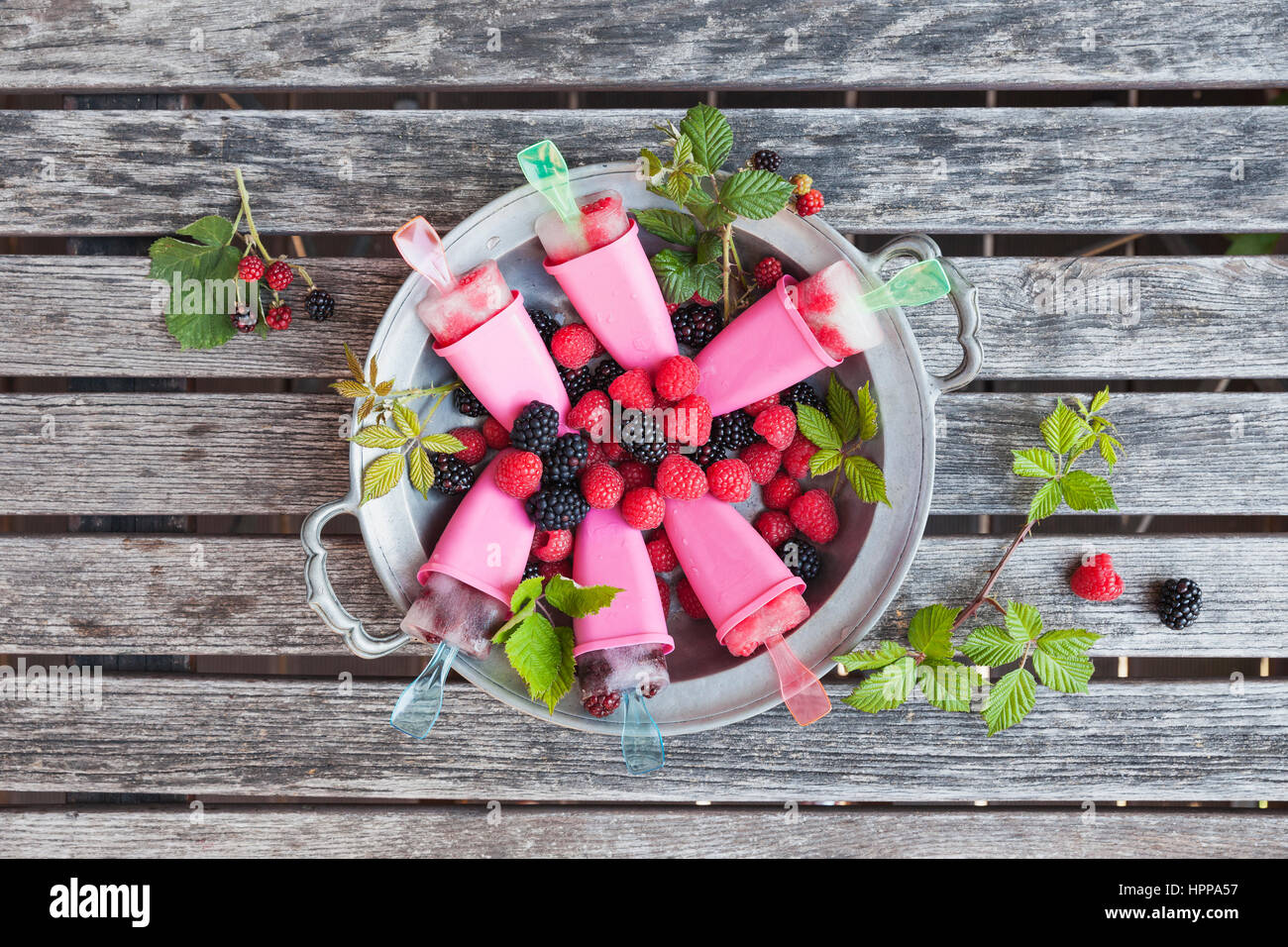 Zinn Teller mit hausgemachten Limonade Eis am Stiehl mit Himbeeren und Brombeeren Stockfoto