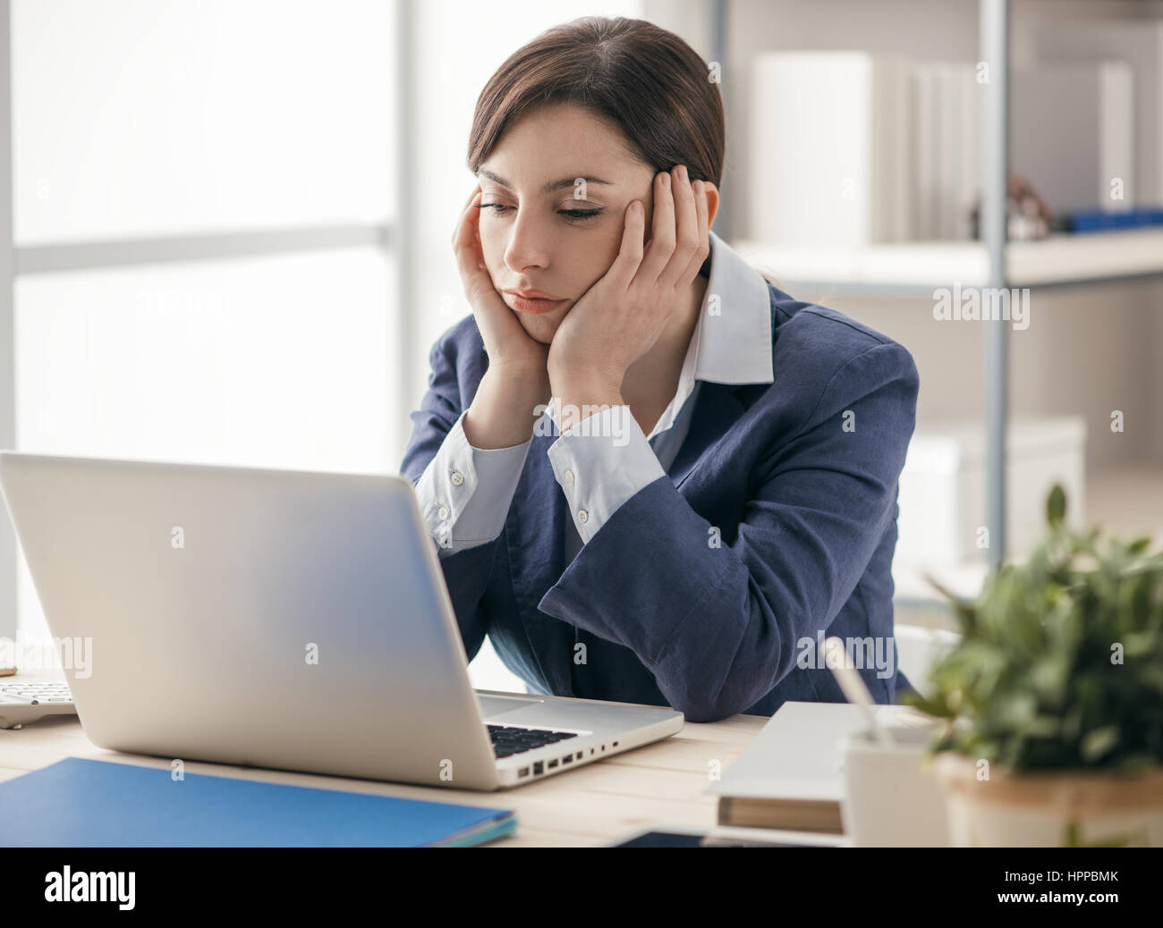 Deprimiert, gelangweilt Geschäftsfrau arbeiten an Schreibtisch und Vernetzung mit einem Laptop, langweiligen Job-Konzept Stockfoto