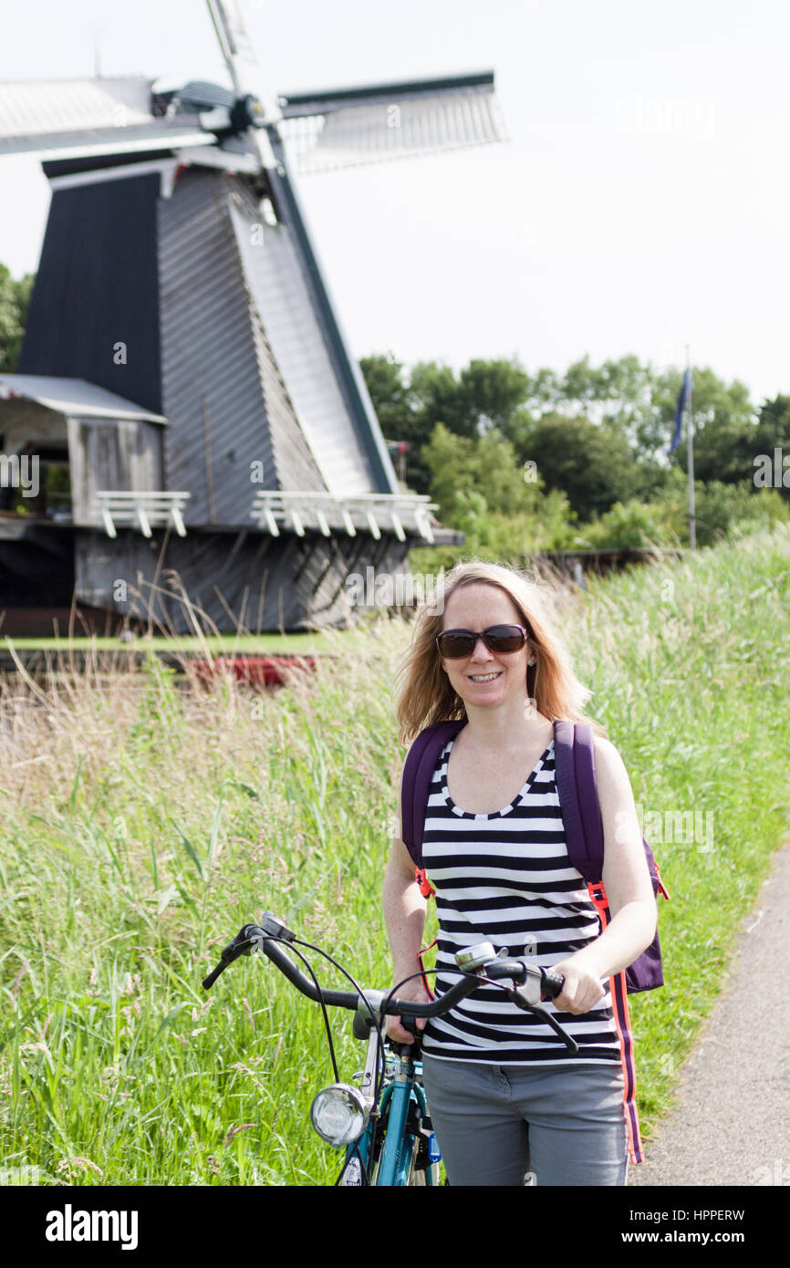 Frau mit Fahrrad unterwegs Zuider Buiten Spaarne Fluss, Stadtrand von Haarlem Stockfoto