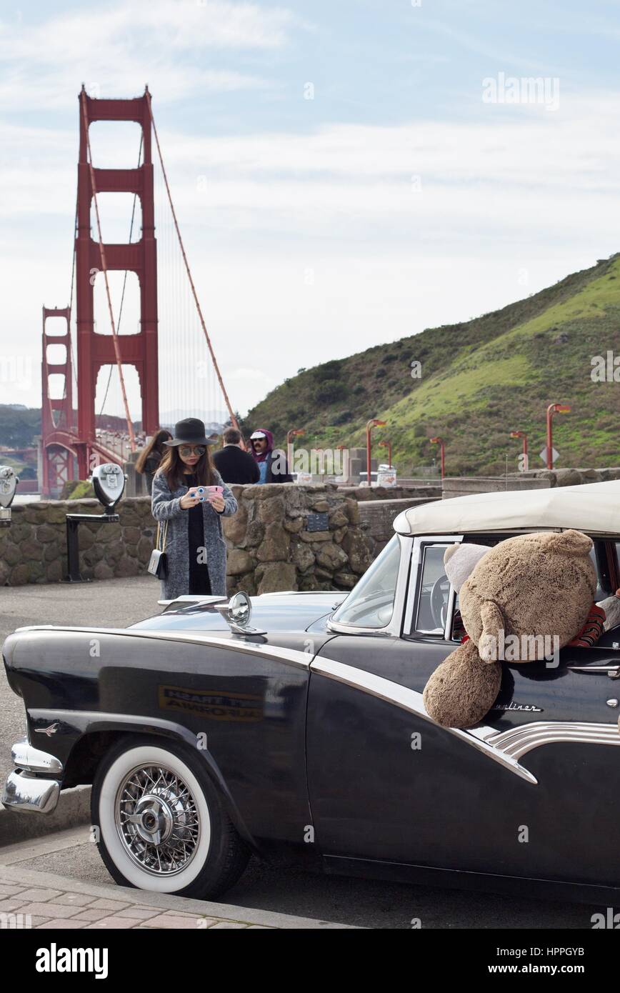 Ein Tourist eine Aufnahme eines Oldtimers voll von riesigen Teddybären im Beobachtungsbereich der Golden Gate Bridge in San Francisco, CA, USA. Stockfoto