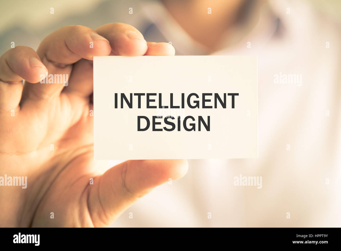 Closeup auf Geschäftsmann hielt eine Karte mit Text INTELLIGENT DESIGN, Firmen-Konzept-Image mit soft-Fokus-Hintergrund und Vintage-Ton Stockfoto