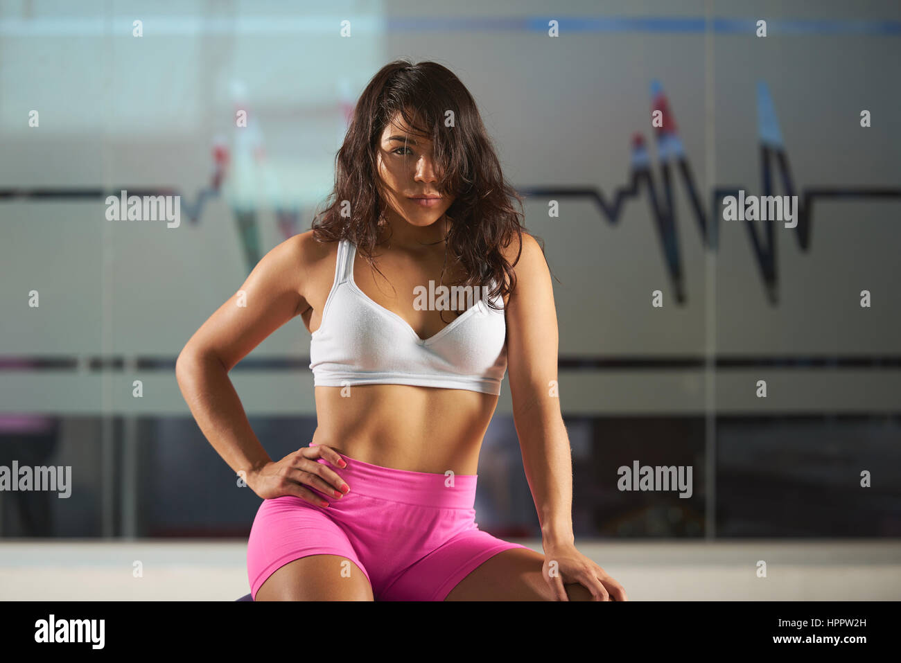 Mädchen sitzen auf Fitball auf modernes Fitness-Studio-Hintergrund. Ein junges Mädchen Hispano-Amerikaner nach Pilates Übung Stockfoto