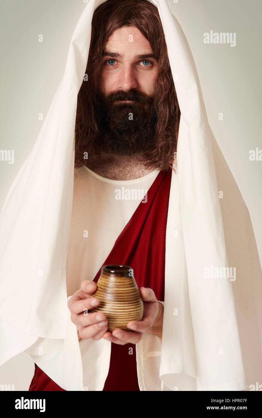 Jesus trägt Gewand mit Weihwasser auf das Glas Stockfoto