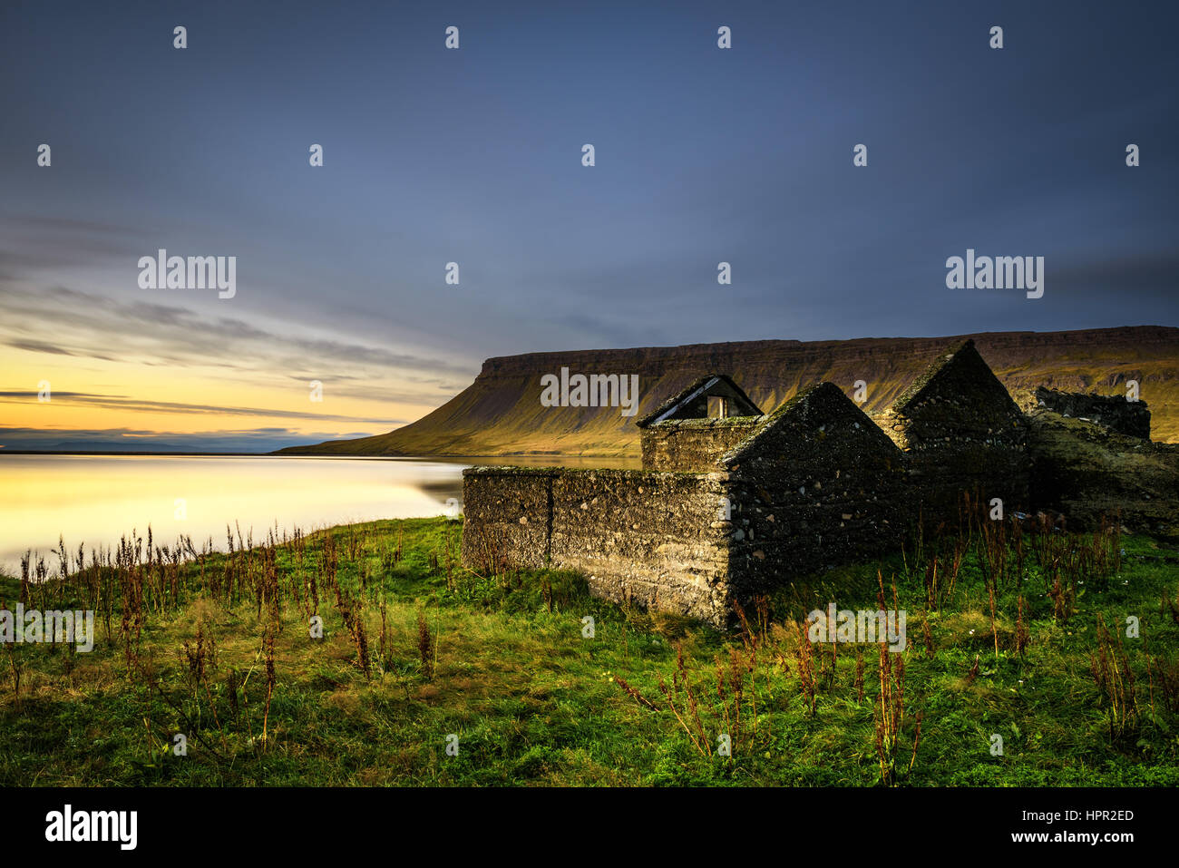 Malerische Landschaft einschließlich Hausruine, typische Klippen und einem See in Island. Langzeitbelichtung. Stockfoto
