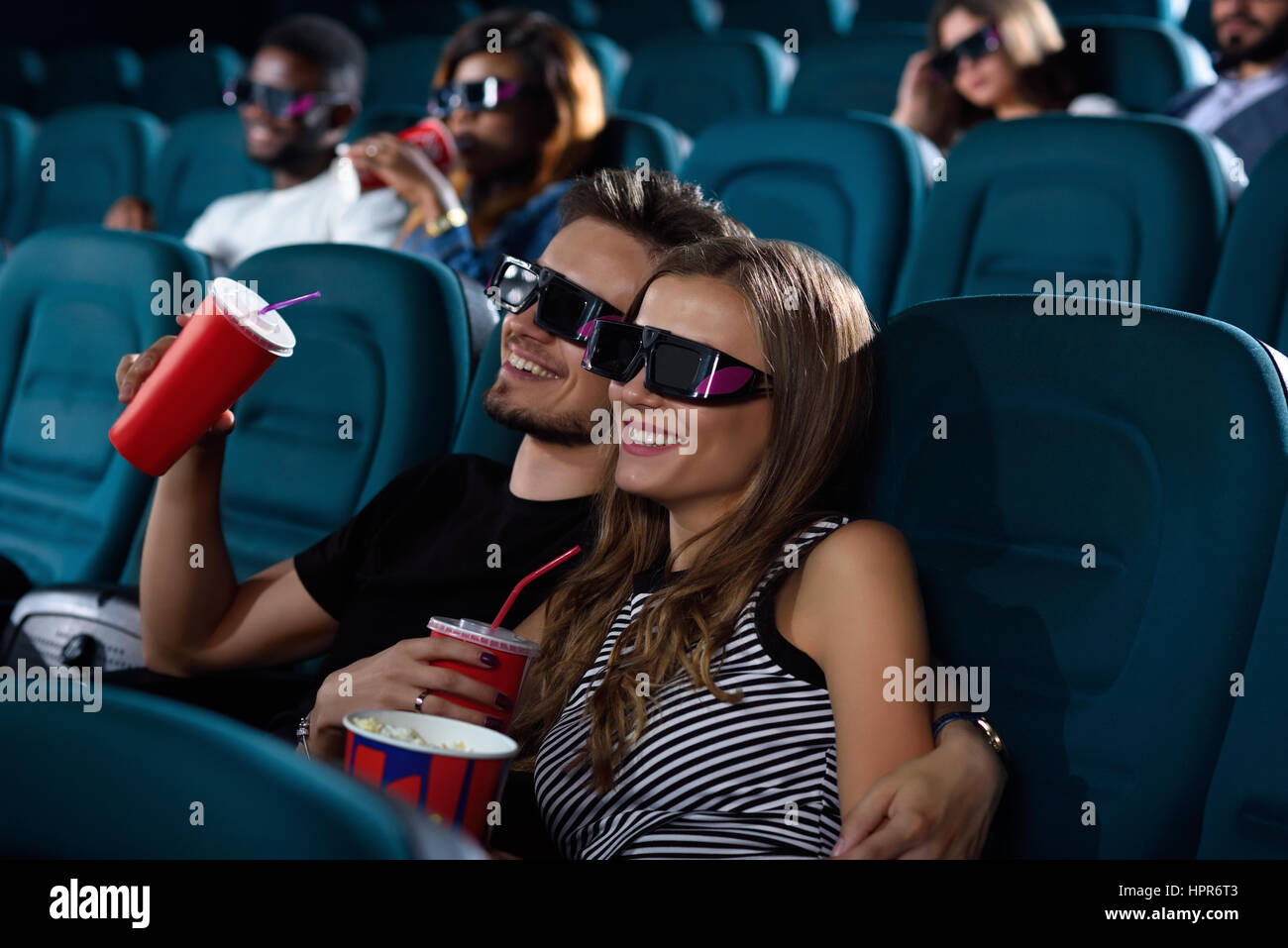 Movieholics Wunderschone Junge Frau Lachelt Glucklich Beim Kuscheln Mit Ihrem Hubschen Freund Wahrend Der Filme Im Kino Stockfotografie Alamy