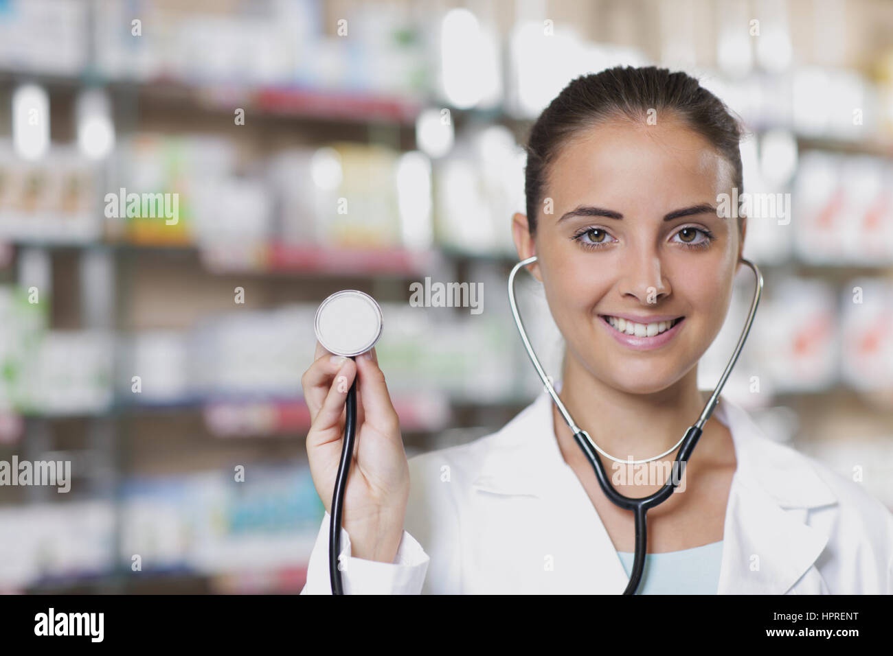 Junge Frau Doktor mit Stethoskop in Apotheke Stockfoto