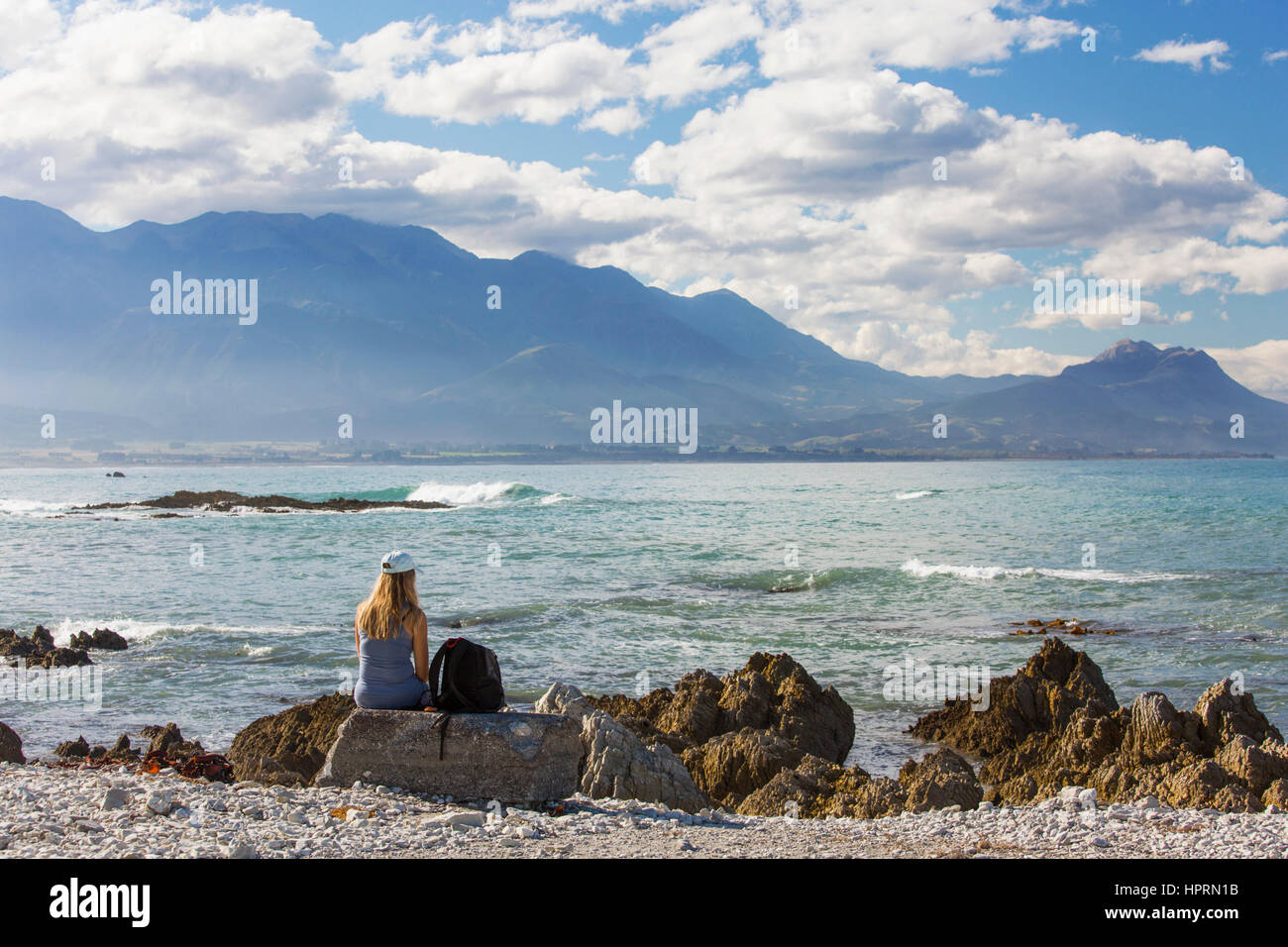 Kaikoura, Neuseeland. Blick über Bucht auf der seewärtigen Kaikoura Range, junge Frau, Blick auf das Meer. Stockfoto