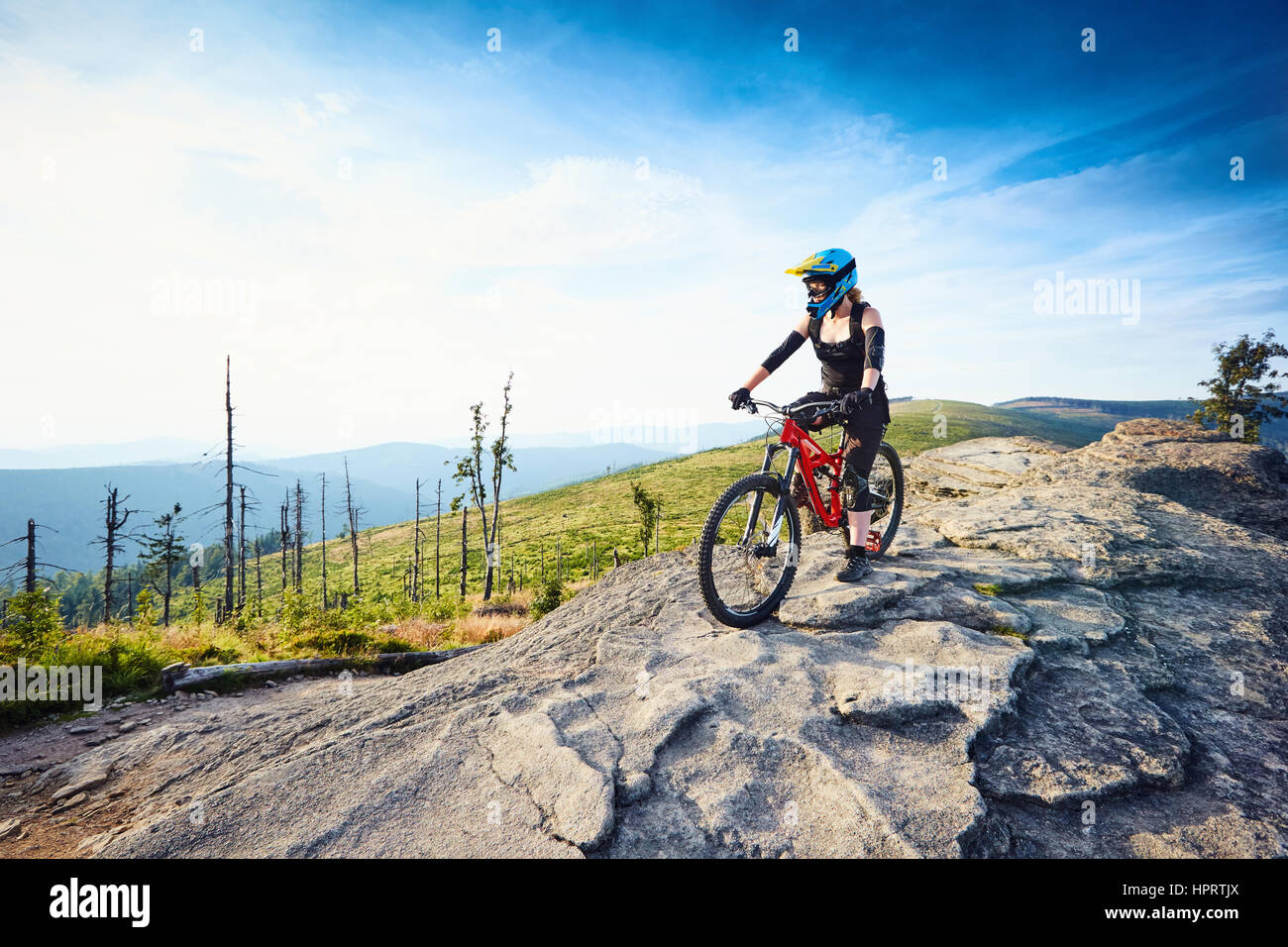Weibliche MTB Mountainbiker genießt die Aussicht während der sonnigen Tag in Bergen Stockfoto