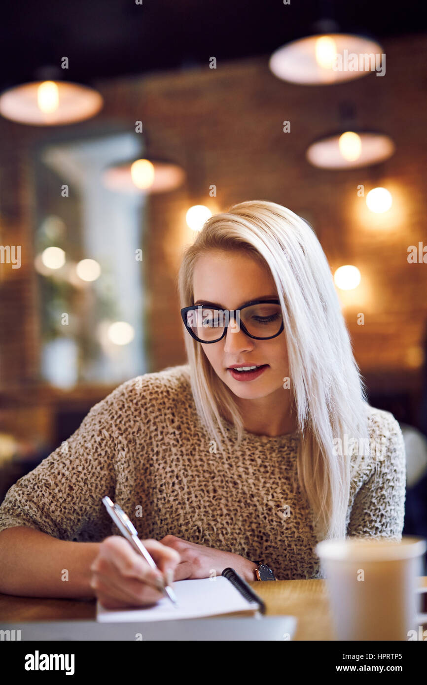 Junge Frau studieren von Café während der Kaffeepause Stockfoto
