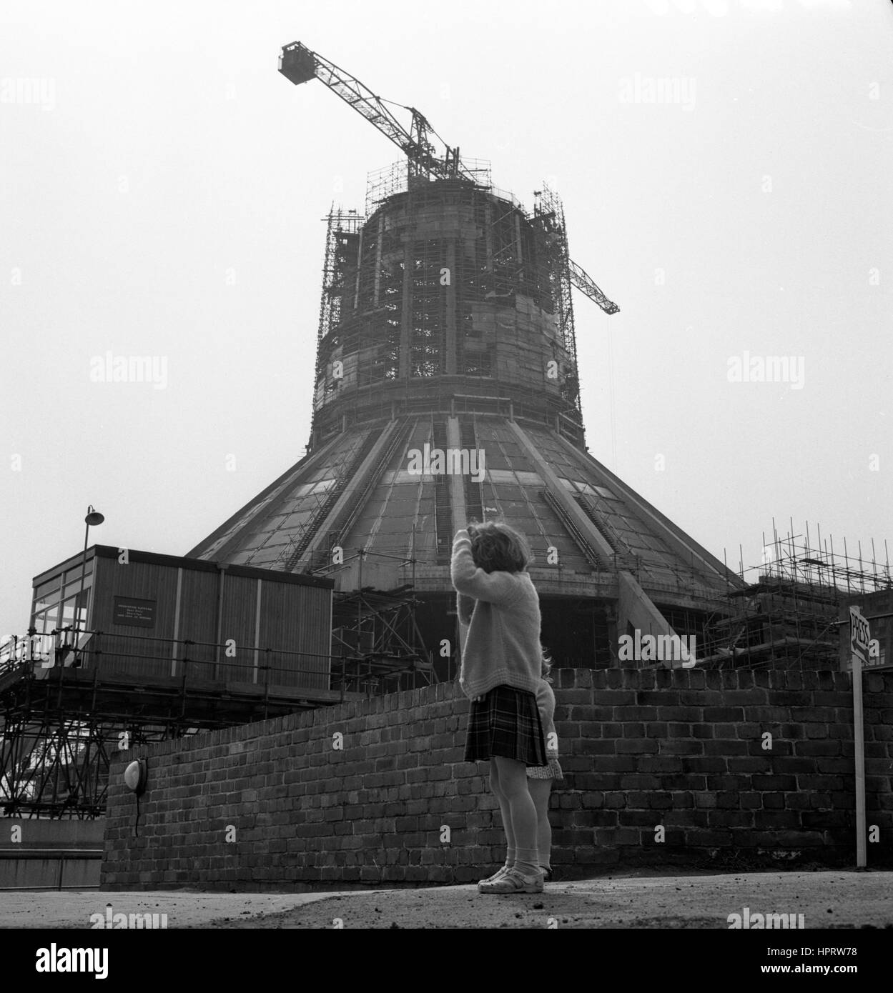 Zwei Mädchen in Liverpool anzeigen Fortschritte auf der Stadt römisch-katholisch Metropolitan Kathedrale von Christus dem König jetzt in einem fortgeschrittenen Stadium des Aufbaus. Baubeginn im Jahre 1962, und es ist fertiggestellt im Jahre 1966 mit einer feierlichen Eröffnung im Jahre 1967. Stockfoto