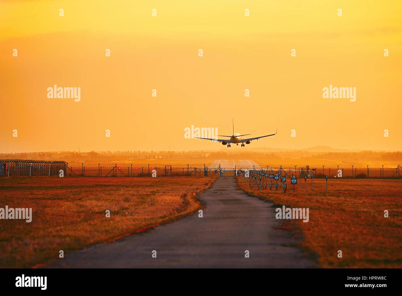 Flugzeug Landung auf dem Flughafen während der goldenen Sonnenuntergang. Stockfoto
