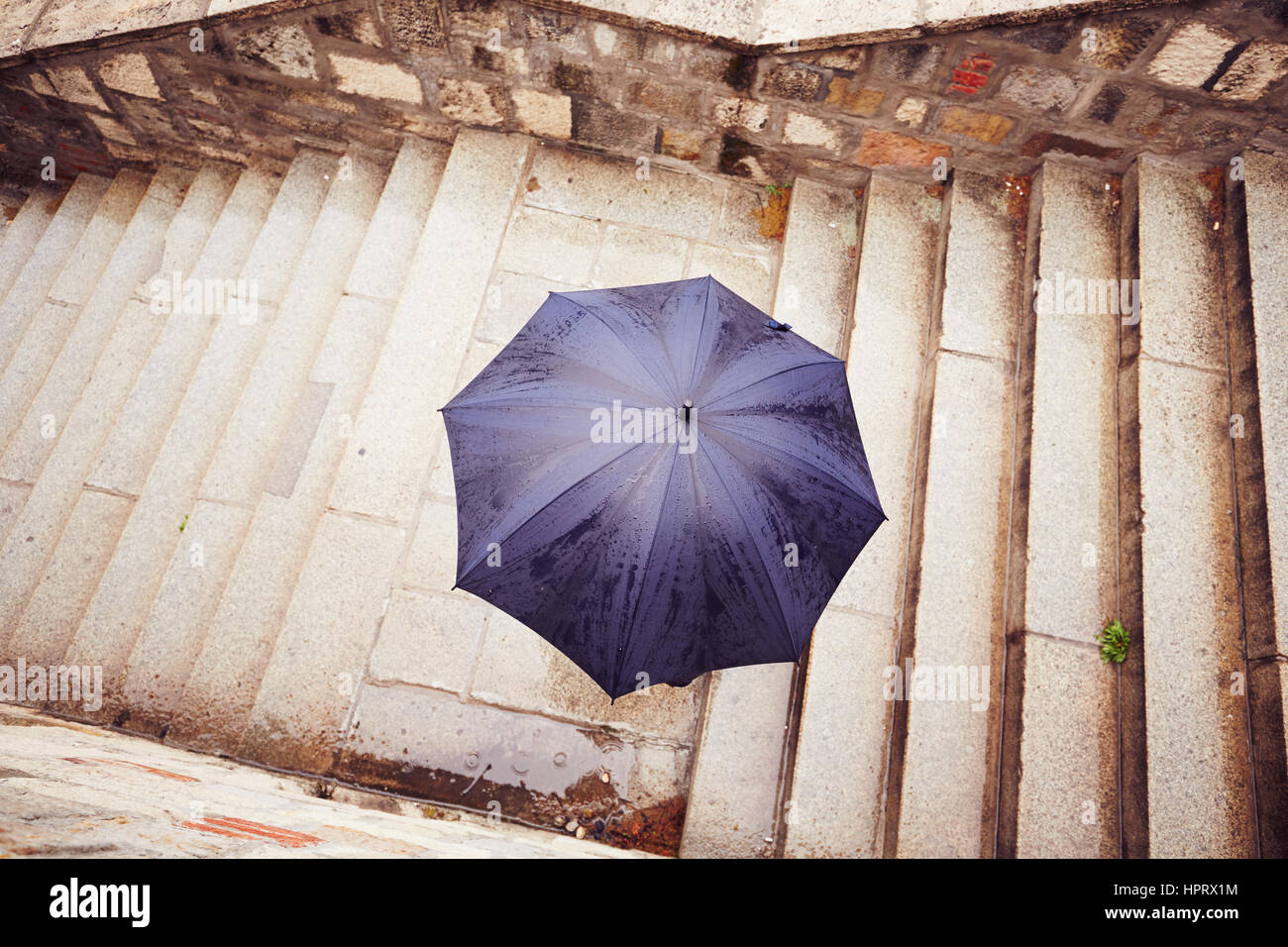 Regen Sie in der Stadt - Mann mit blauen Schirm Stockfoto