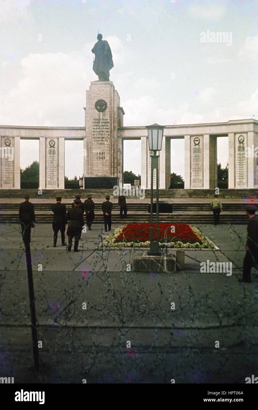 Ostdeutschen Soldaten stehen stramm und zeigen das Sowjetische Ehrenmal (Tiergarten) in Ostberlin, Deutschland, mit Stacheldraht sichtbar in den Vordergrund, während des Kalten Krieges, 1965. Stockfoto