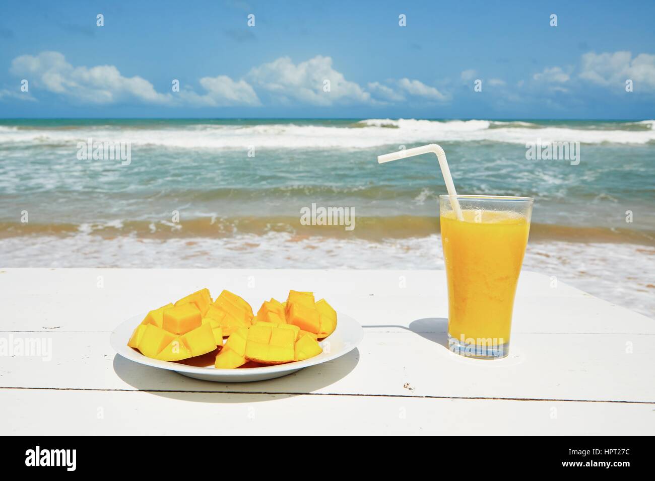 Frische Mango-Frucht und Saft am Strand Stockfoto