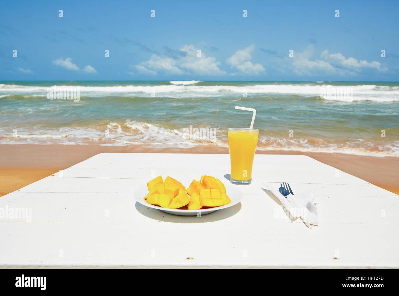 Frische Mango-Frucht und Saft am Strand Stockfoto
