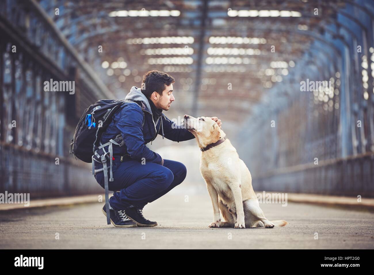 Mann mit seinem gelben Labrador Retriever auf der alten Brücke Stockfoto