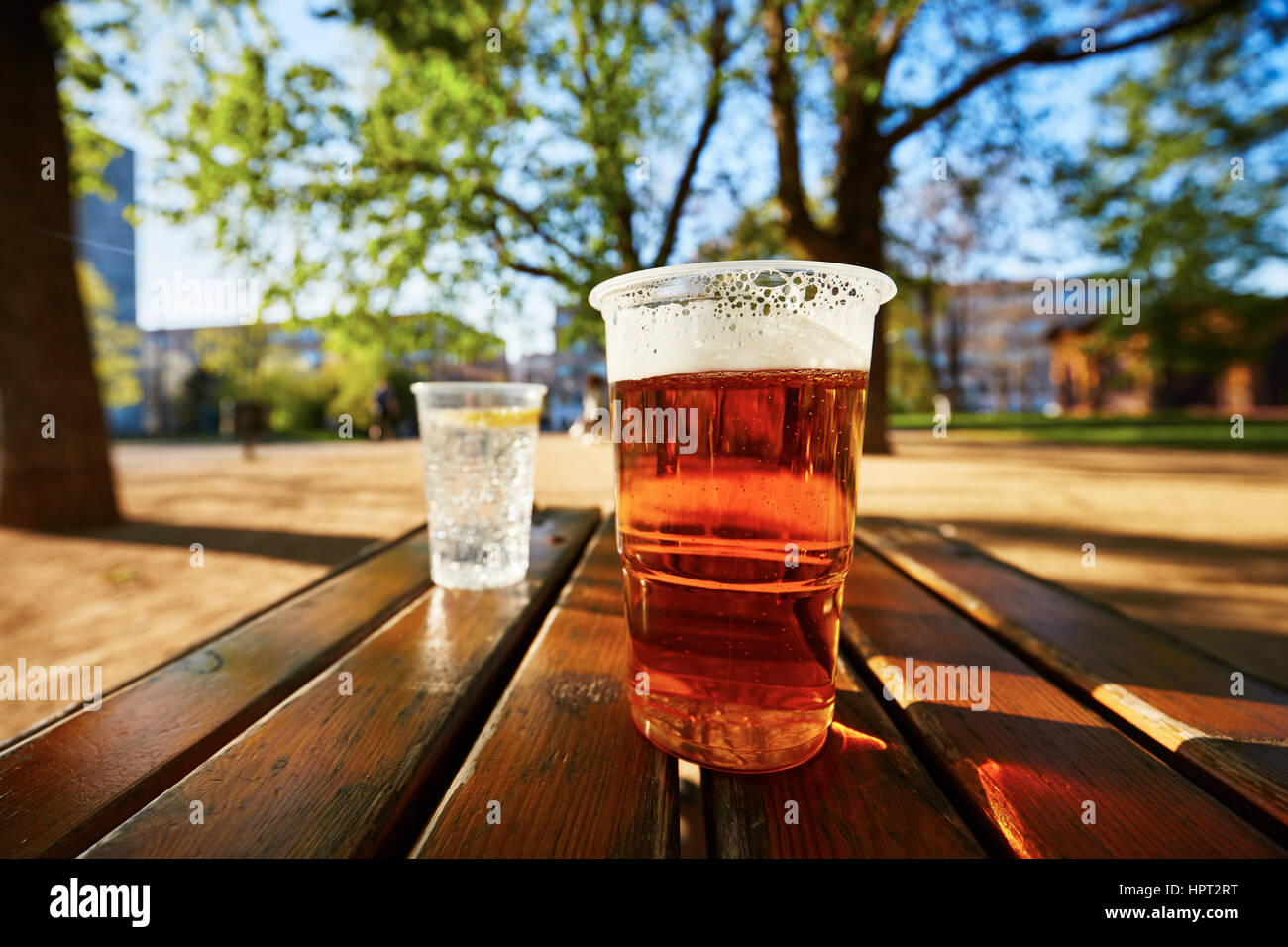 Tassen von Bier und Wasser im Garten-restaurant Stockfoto