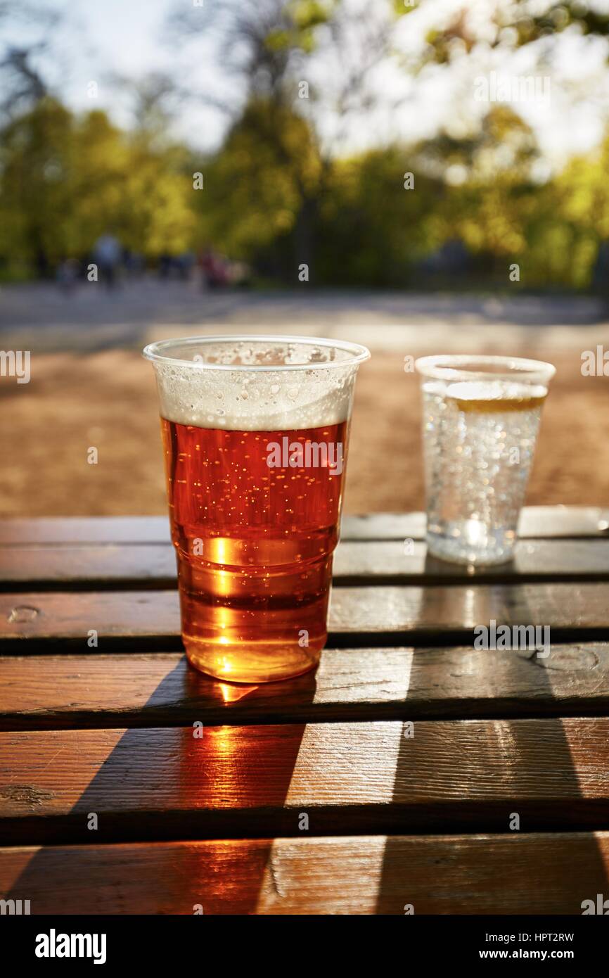 Tassen von Bier und Wasser im Garten-restaurant Stockfoto