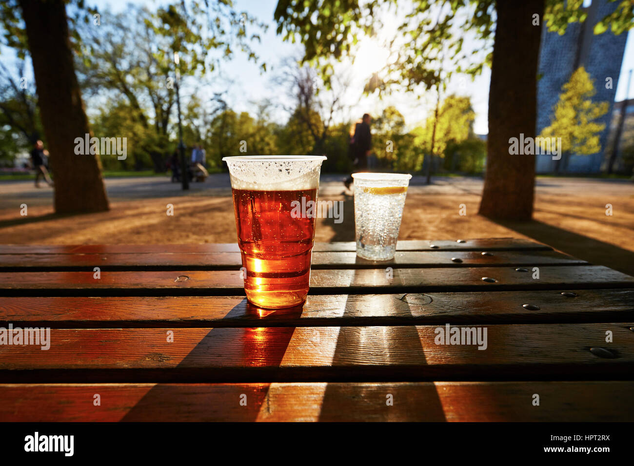 Tassen von Bier und Wasser im Garten-restaurant Stockfoto