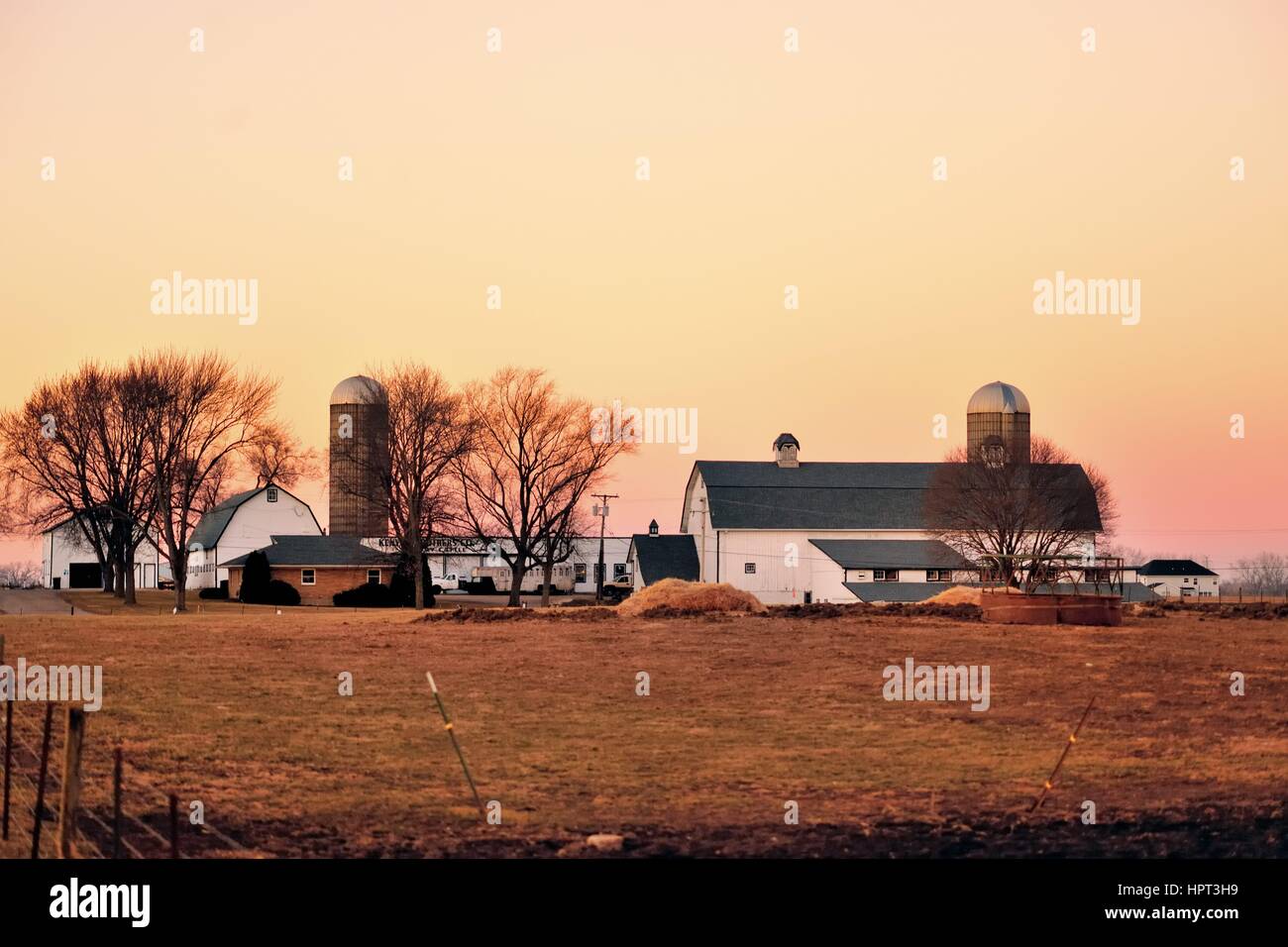 Dämmerung, kurz nach Sonnenuntergang, steigt auf einer Molkerei an einem Winterabend im Nordosten von Illinois in der Gemeinschaft von South Elgin, Illinois, USA. Stockfoto