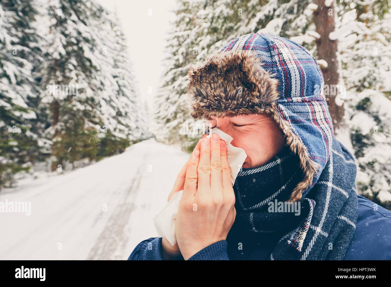 Kranker Mann mit Papiertuch in der Winter-Natur - Gesundheit und Medizin-Konzept Stockfoto
