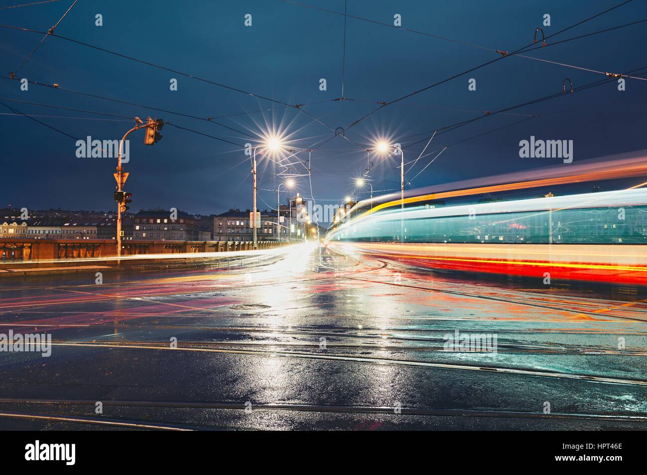 Lichtspuren auf der Kreuzung in regnerischen Nacht in der Stadt. Prag, Tschechische Republik. Stockfoto